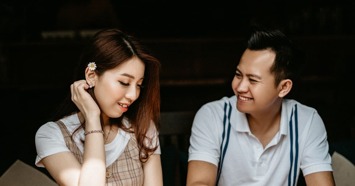 카페에 나란히 앉아 미소 짓는 두 사람